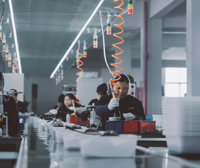 Operarios trabajando en una línea de producción industrial